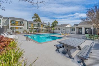 A swimming pool with a picnic table and chairs around it